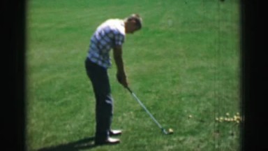 1968: Teenage boy swinging golf club behind front view with high speed slow