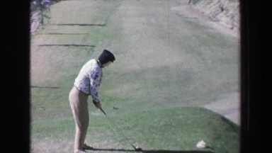 1968: Women golfer driving tee plays beautiful mountain golf course on summer