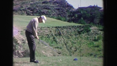 1968: Golfing man hits drive on fancy golf course into challenging fairway. PALM