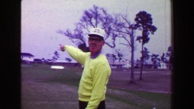 1968: Man golf hole-in-one shot pull ball out hole happy jumps excitedly. AMES,