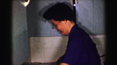 1958: Woman Hand Washing Dishes After Dinner in St. Louis Kitchen Sink