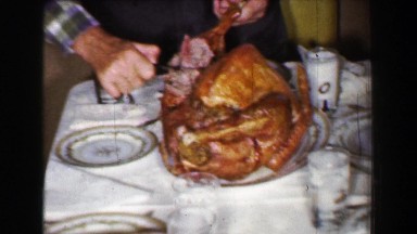 1958: Family enjoying Thanksgiving dinner with giant cooked turkey meal. ST.