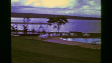 1977: Vacation spot pool hotel resort woman visiting happy with choice.