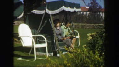 1947: Mother daughter sitting outdoor palm tree lounge chair furniture. MIAMI