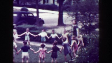 1949: Schoolmarm teacher playing Hooky Pooky childhood game in house front yard.