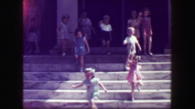 1949: Kids leaving school walk down slick stone staircase with no handrails,
