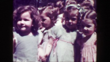 1949: School children closeup running woman teachers flower print dress. MACON,