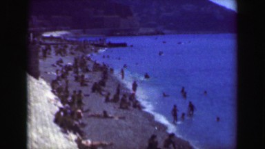 1949: French Riviera crowded beach boardwalk summer vacation blue sky. NICE,