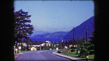 1944: Mansion on the hill overlooking ocean bay water mountain landscape.