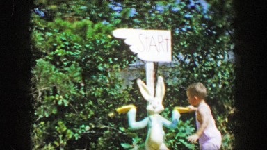 1955: Storyland theme park boy admires start sign bugs bunny rabbit character.