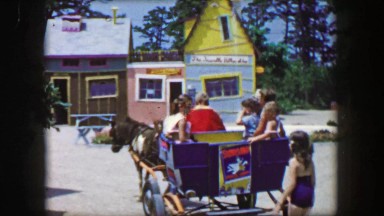 1955: Storyland theme park horse drawn carriage pulling cart of kids amusement