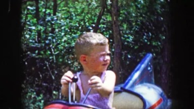 1955: Storyland theme park boy riding rocket amusement toddler kid ride.