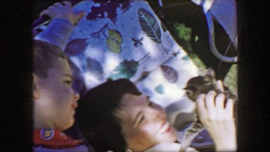 1957: Mother son playing cute kitten outdoor tree shade summer relaxing. GLEN,