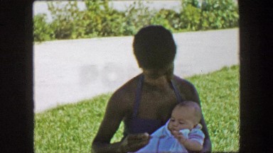 1957: African American Woman Feeding Caucasian Child with Spoon