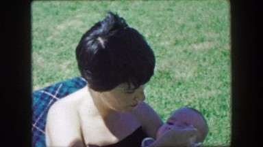1957: Mother feeding chubby baby boy outdoor summer park chair. GLEN, NEW
