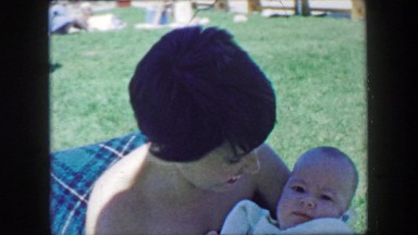 1957: Mother feeding chubby baby boy outdoor summer park chair. GLEN, NEW