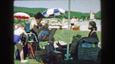 1957: Mother feeding baby at outdoor public swimming pool location. GLEN, NEW