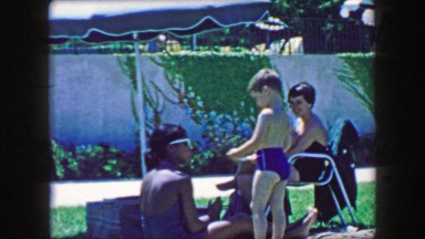 1957: Multiracial family friends enjoying public pool summertime relaxation.