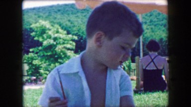 1957: Adorable boy kid holding paint brush explaining his artistic vision. GLEN,
