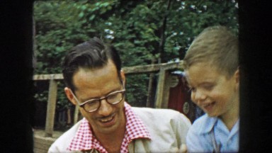 1957: Father son petting zoo closeup fun popcorn food to animals. GLEN, NEW
