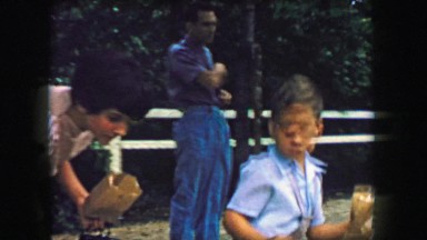 1957: Boy feeding animals petting zoo bag of popcorn food. GLEN, NEW HAMPSHIRE