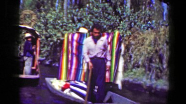 1951: Merchants selling colorful blankets on river boat tourist cruise trip
