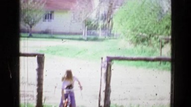 1957: Happy Girl in Yellowstone T-Shirt Riding Tricycle on Sidewalk in Baton Rouge