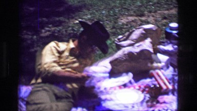 1957: Man in black cowboy hat enjoying picnic sunshine lunch feast. BATON ROUGE,