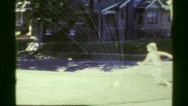 1961: kids running through sprinkler IOWA