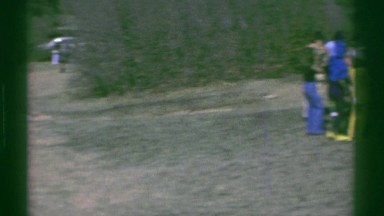 1961: mostly children and a few adults run out into a bush filled field to play