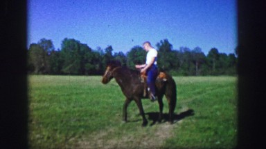 1961: horseback rider trots on trail in meadow IOWA