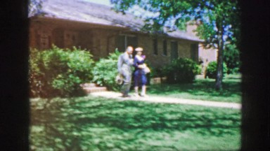 1961: well-dressed couple strolls along path toward onlooker IOWA