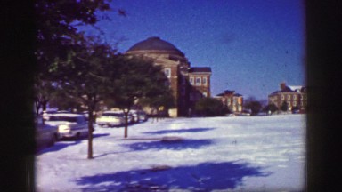1961: the video shows an outdoor scene with snow and buildings and few cars