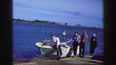 1961: people are seen posing beside a boat IOWA