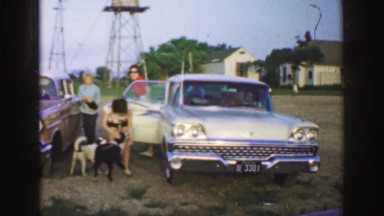 1961: women exiting a vehicle and being greeted by a couple of cute dogs IOWA