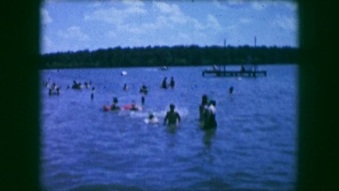 1961: family and children swimming, splashing and playing in a lake IOWA