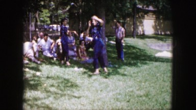 1961: people are seen exercising in a park, and are seen throwing a woman