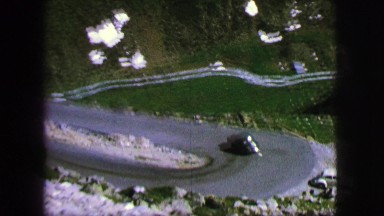 1963: car traveling snow patch covered mountain road passes second vehicle