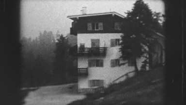 1963: beautiful view of snow atop mountains and homes amid the lush trees