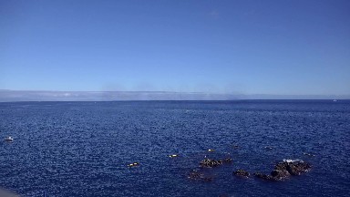 2016: Large Blue Body of Water with Waves Crashing Against Rocks