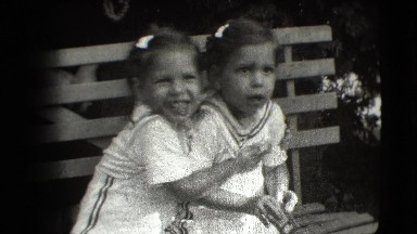 1942: Twins in Matching Dresses Posing on Park Bench