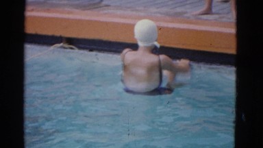 1953: a lady is seen practicing her backstroke in a swimming pool.