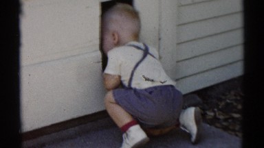 1959: little boy looks through hole DISNEYLAND, CALIFORNIA