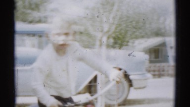 1959: cute blonde boy in jeans attempting to ride his small bike DISNEYLAND