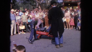1962: a person is seen curing a person who seems to be fainted and the crowd