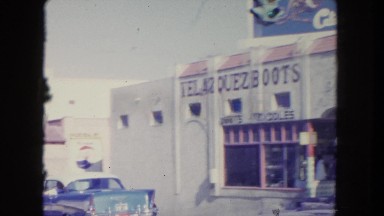1962: the video shows a busy street with cars and people moving around