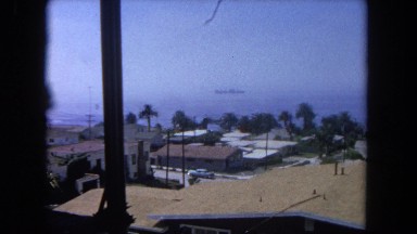 1962: looking out over houses and palm trees to boat SAN PEDRO, CALIFORNIA