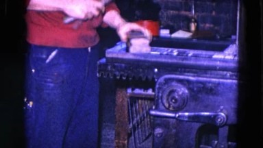1967: Man Hammering Metal Object on Workbench in Pittsburgh, Pennsylvania
