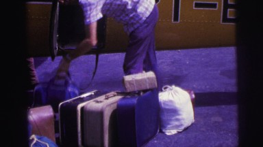 1979: Baggage Handler Loading Luggage Compartment of Airplane