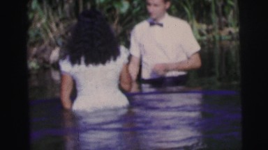 1979: person baptizing a woman in body of water
